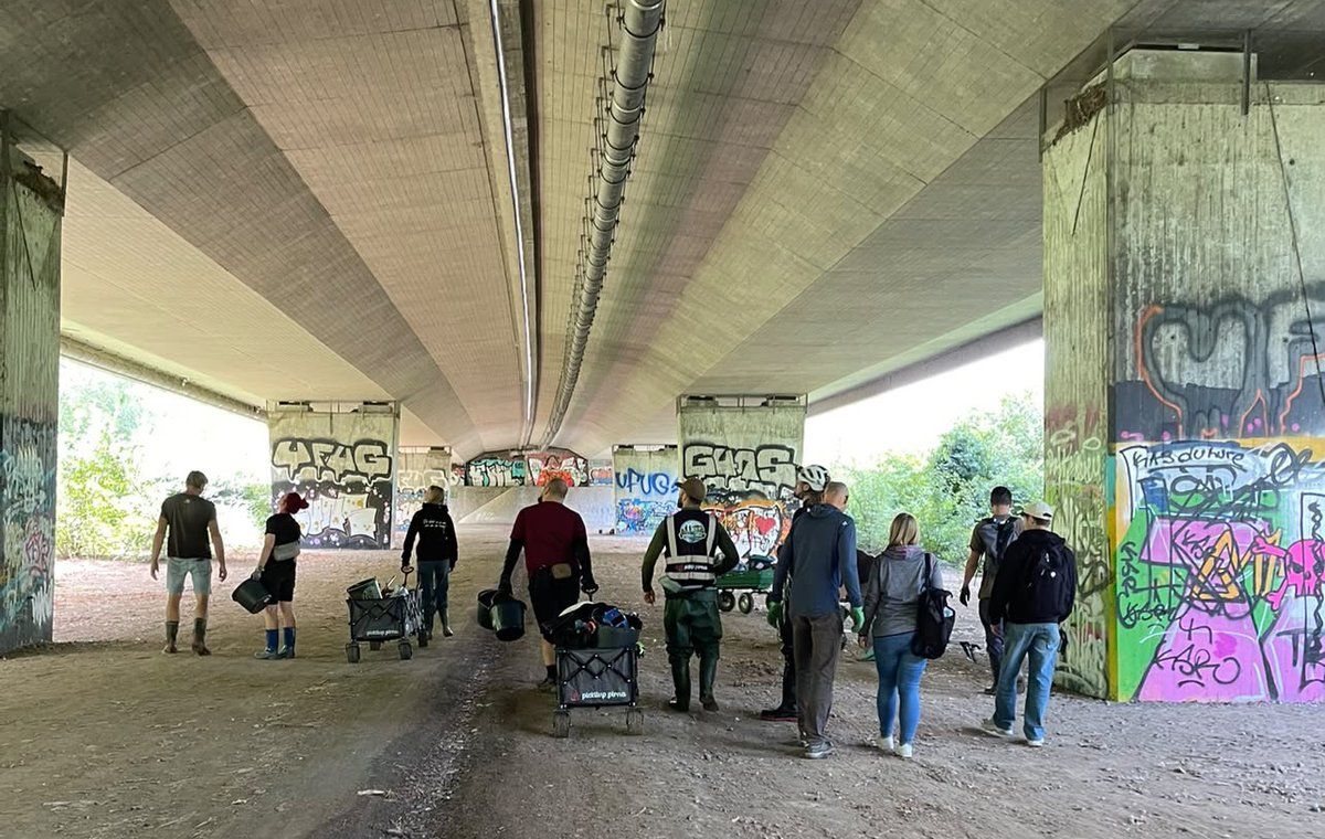 Gruppe von Freiwilligen mit Sammel-Wagen unterwegs